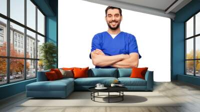 healthcare, profession and medicine concept - happy smiling doctor or male nurse in blue uniform with crossed arms over white background Wall mural