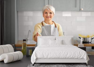 healthy eating, food cooking and culinary concept - happy smiling senior woman making vegetable salad and showing thumbs up on kitchen at home Wall mural