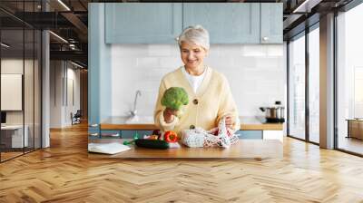 healthy eating, food cooking and culinary concept - happy smiling woman with vegetables in string bag and cook book on kitchen Wall mural