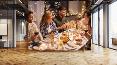 holidays, celebration and people concept - happy friends having christmas dinner at home drinking non-alcoholic red wine Wall mural