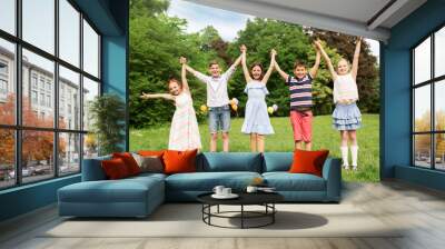 holidays, childhood and celebration concept - happy kids having fun on birthday party at summer park Wall mural