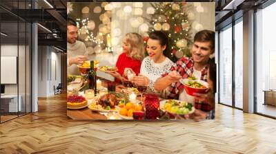 holidays and celebration concept - happy friends having christmas dinner at home and eating food Wall mural