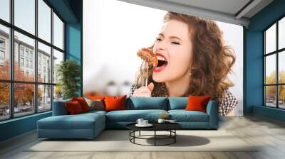 hungry young woman eating meat on fork in kitchen Wall mural