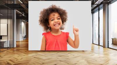 idea, warning and childhood concept - happy little african american girl pointing finger up over grey background Wall mural