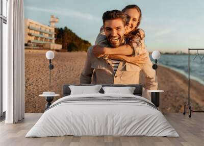 leisure and people concept - happy couple having fun on summer beach Wall mural