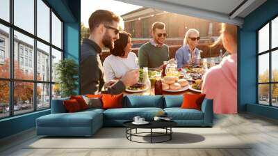 leisure and people concept - happy friends having dinner or barbecue party and eating on rooftop in summer Wall mural