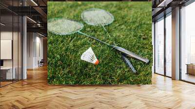 leisure games and sport equipment concept - close up of badminton rackets and shuttlecock on grass Wall mural