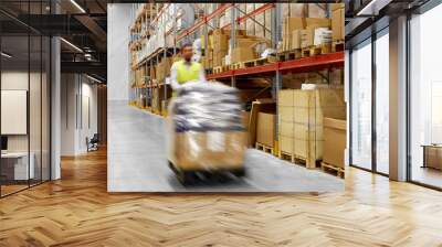 logistic business, shipment and loading concept - motion blurred picture of worker carrying loader with goods at warehouse Wall mural