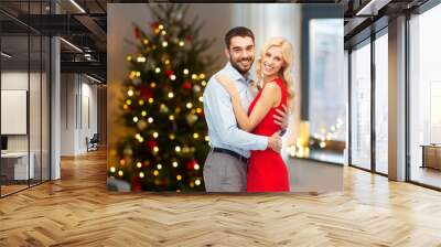 love and holidays concept - happy couple hugging over home room with christmas tree background Wall mural