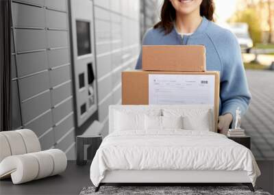 mail delivery and post service concept - close up of happy smiling woman with boxes at outdoor automated parcel machine Wall mural