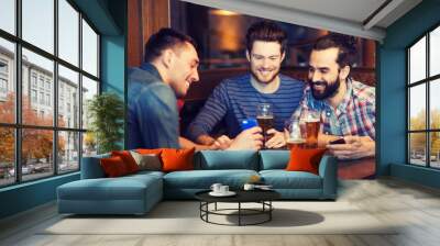 male friends with smartphones drinking beer at bar Wall mural