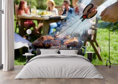 man cooking meat on barbecue grill at summer party Wall mural