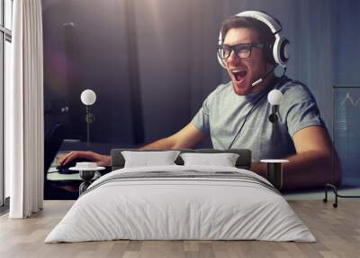 man in headset playing computer video game at home Wall mural