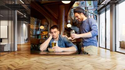 man with beer and drunk friend at bar or pub Wall mural