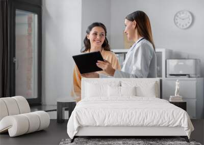 medicine, healthcare and people concept - female doctor with tablet pc computer talking to smiling woman patient at hospital Wall mural