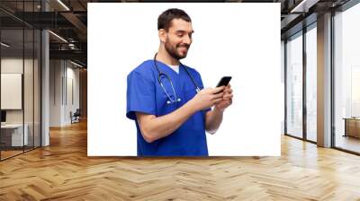 medicine, healthcare and technology concept - happy smiling doctor or male nurse in blue uniform with stethoscope using smartphone over white background Wall mural