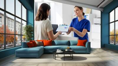 medicine, people and healthcare concept - female doctor or nurse with clipboard and patient at hospital Wall mural