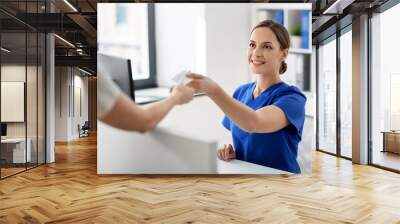 medicine, people and healthcare concept - happy smiling female doctor or nurse and patient with prescription at hospital Wall mural