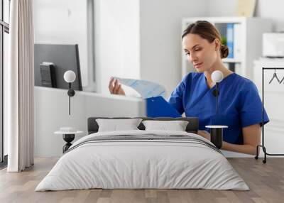 medicine, technology and healthcare concept - female doctor or nurse with clipboard working at hospital Wall mural