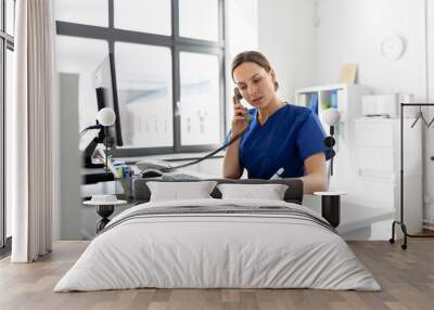 medicine, technology and healthcare concept - female doctor or nurse with computer and clipboard calling on phone at hospital Wall mural