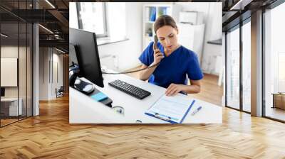 medicine, technology and healthcare concept - female doctor or nurse with computer and clipboard calling on phone at hospital Wall mural