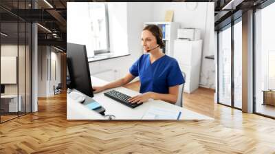 medicine, technology and healthcare concept - happy smiling female doctor or nurse with headset and computer working at hospital Wall mural