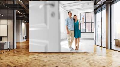 mortgage, people and real estate concept - happy couple hugging at new home Wall mural