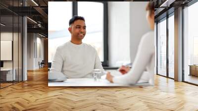 new job, business and employment concept - smiling indian male employee having interview with female employer or hr manager at office Wall mural