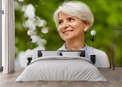 old age, retirement and people concept - portrait of happy senior woman at summer park Wall mural