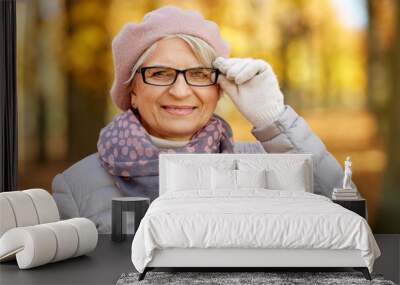 old age, retirement and season concept - portrait of happy senior woman in glasses at autumn park Wall mural