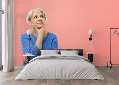 old people and decision making concept - portrait of senior woman in blue sweater thinking over pink or living coral background Wall mural