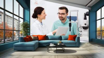 optician with tablet pc and patient at eye clinic Wall mural