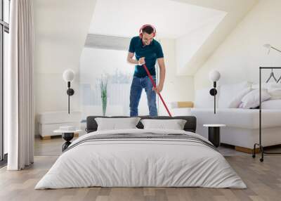 people, housework and housekeeping concept - happy man in headphones with mop cleaning floor at home Wall mural