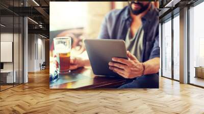 people, leisure and technology concept - close up of man with tablet pc computer drinking beer at bar or pub Wall mural