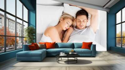 people, rest and relationships concept - happy couple sleeping in bed at home Wall mural