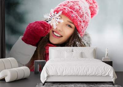 people, season and christmas concept - portrait of happy smiling teenage girl or young woman with snowflake in winter park Wall mural