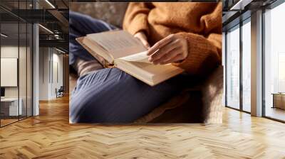 people, season and leisure concept - close up of woman in warm sweater reading book at home Wall mural