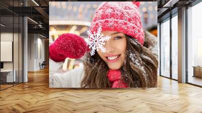 people, season and winter holidays concept - portrait of happy smiling teenage girl or young woman with snowflake over christmas lights in amusement park on background Wall mural