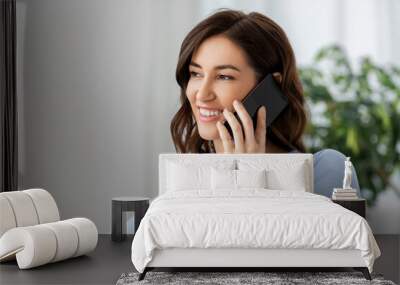 people, technology, communication and leisure concept - happy young woman calling on smartphone at home Wall mural