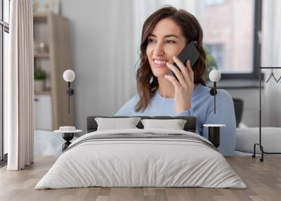 people, technology, communication and leisure concept - happy young woman calling on smartphone at home Wall mural