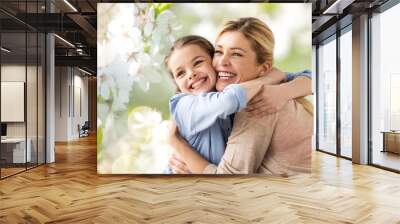 people and family concept - happy smiling mother hugging daughter over cherry blossom background Wall mural