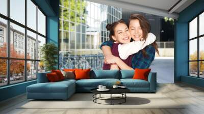 people and friendship concept - happy smiling teenage girls hugging over city street or school yard background Wall mural