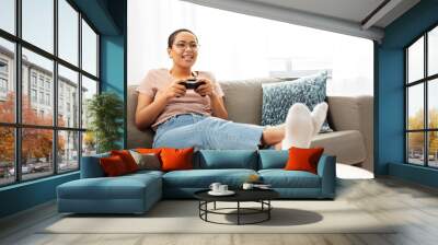 people and leisure concept - happy smiling african american young woman with gamepad playing video game at home Wall mural