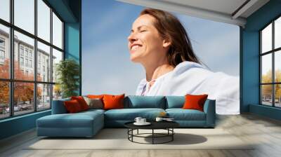 people and leisure concept - happy smiling woman enjoying sun Wall mural