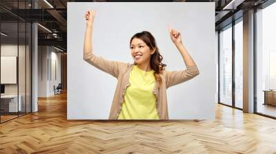 people and leisure concept - happy young asian woman dancing over grey background Wall mural