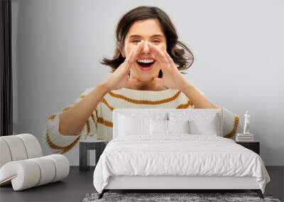 people concept - happy smiling young woman in striped pullover calling someone over grey background Wall mural