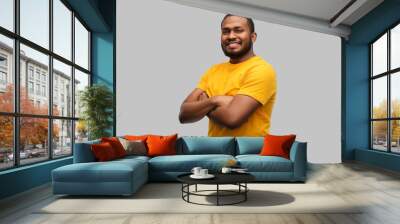 people concept - smiling young african american man in yellow t-shirt with crossed arms over grey background Wall mural