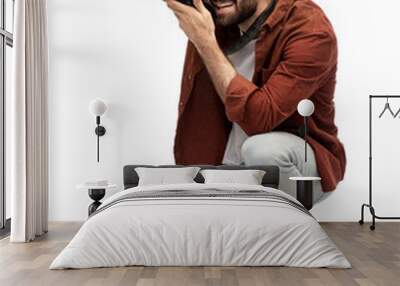 photography, profession and people and concept - happy smiling man or photographer with digital camera staying on one knee and taking picture over white background Wall mural