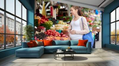 pregnant woman choosing food at street market Wall mural