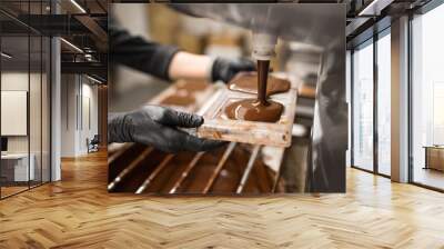 production, cooking and people concept - confectioner filling candy mold with chocolate at confectionery shop Wall mural